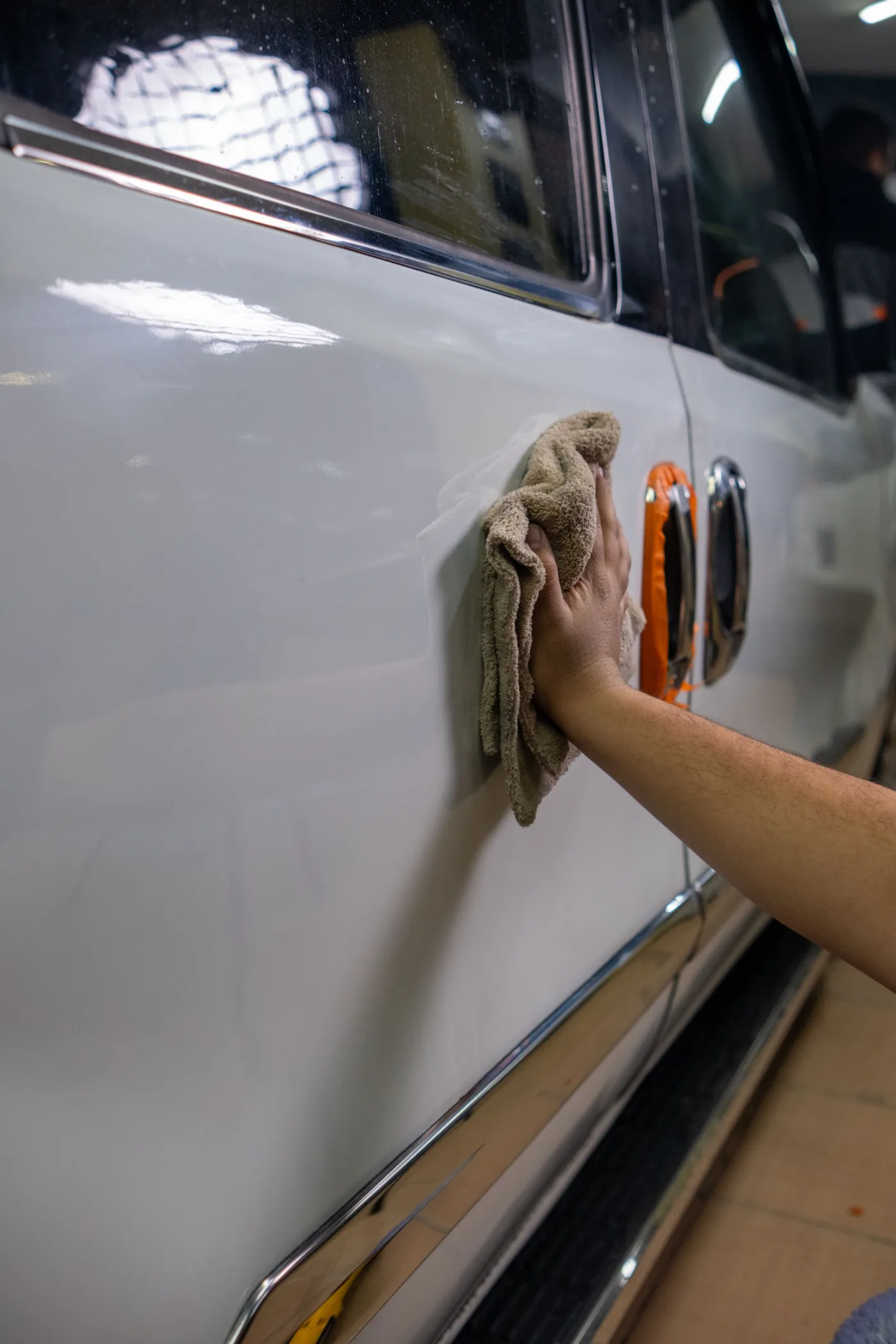 A vehicle exterior being wiped with a microfiber towel