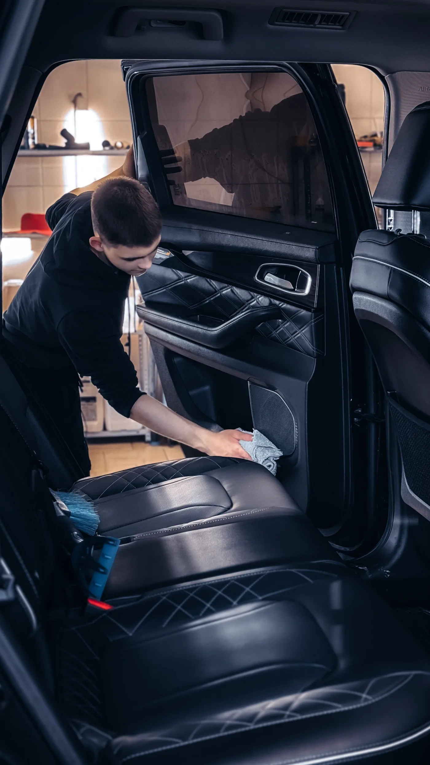 Detailer wiping the rear seat area of a vehicle